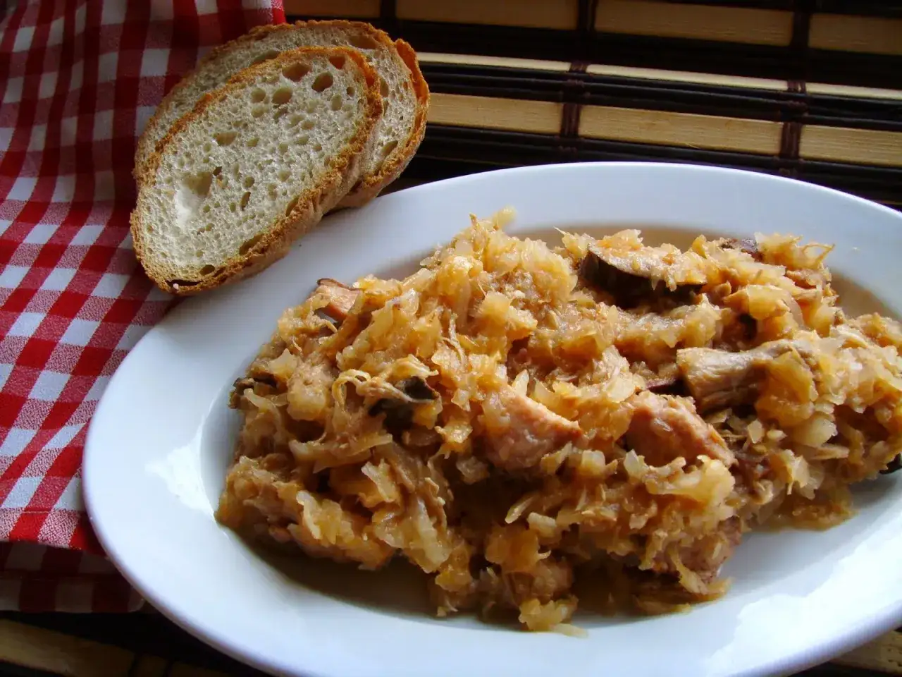 Talerz z bigosem i kromkami chleba. Czy pies może jeść bigos? Zależy od składników, ale ten wygląda apetycznie dla ludzi.